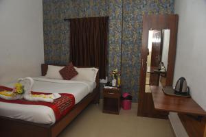 ein Hotelzimmer mit Bett und Spiegel in der Unterkunft RD HOTEL-Bhavani Road in Erode