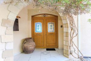 a wooden door with a vase in front of it at Resitour - Kamares Village in Paphos +22 photos