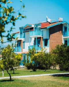 ein großes Gebäude mit blauen Balkonen und Bäumen in der Unterkunft Yonca Lodge in Fethiye