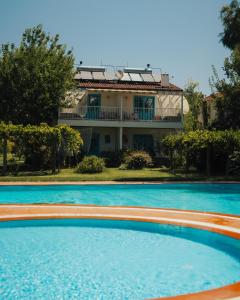 ein großer Swimmingpool mit einem Haus im Hintergrund in der Unterkunft Yonca Lodge in Fethiye
