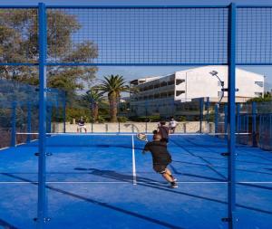 a young boy playing tennis on a tennis court at Livadi Nafsika Hotel in Dassia