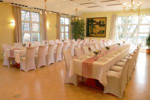 a row of tables and chairs in a room at Hotel Landgut Burg in Weinstadt