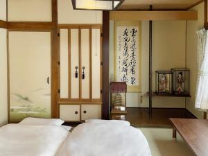 a bedroom with two beds in a room with writing on the wall at Hi Song Villa in Otaru