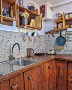 a kitchen with a sink and wooden cabinets at Thee&Thou Cottage in Breaza
