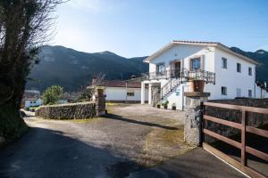 a white house with a fence and mountains in the background at Casa vacacional El Angel in La Pesa
