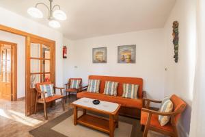 a living room with an orange couch and chairs at Casa vacacional El Angel in La Pesa