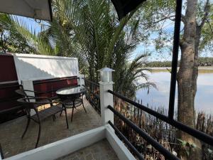 a balcony with a table and chairs and a view of the water at Rainbow Arokaya Welness Resort in Ban Hua Sai +17 photos