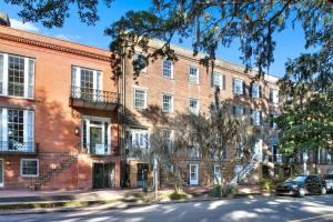 a large red brick building with cars parked in front at Oglethorpe Manor Main House in Savannah