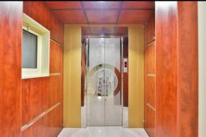 a walk in shower in a room with wooden walls at عمارة النفيسة شقة 9 in Unayzah