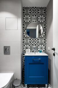 a bathroom with a blue cabinet and a mirror at Aviva Living by Flat Mаnager in Sofia +25 photos