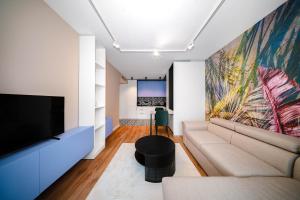 a living room with a couch and a flat screen tv at Aviva Living by Flat Mаnager in Sofia