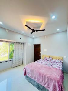 a bedroom with a bed and a ceiling fan at Suits by lowtide in Udupi