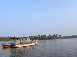 a boat with a cabin on the water at Suits by lowtide in Udupi