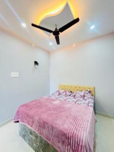 a bedroom with a bed and a ceiling fan at Suits by lowtide in Udupi +1 photo