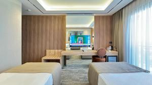 a hotel room with two beds and a desk at Solia Hotel in Mezitli +21 photos