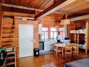 a kitchen and dining room with a table in a cabin at Riverside Cottage Äänekoski Sauna Hot Tub Northern Lights in Äänekoski