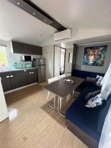 a living room with a blue couch and a table at Sunset Lagoon House in Lagoa
