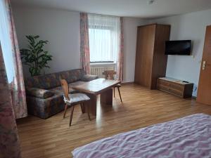 a living room with a couch and a table at Gästezimmer Hagenschieß in Pforzheim