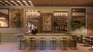a bar in a restaurant with stools and bottles of alcohol at Aria Santa Maria in Santo Domingo