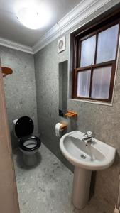 a bathroom with a black toilet and a sink at Ahava Accommodation in Scottburgh