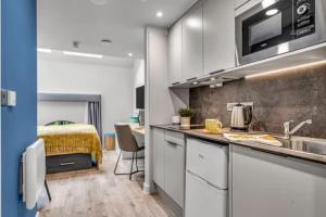 a kitchen with a sink and a bed in a room at Practical Studios In Lincoln with Free Grab&Go Breakfast in Lincoln