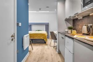 a room with a kitchen with a bed in the background at Practical Studios In Lincoln with Free Grab&Go Breakfast in Lincoln