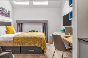 a bedroom with a bed and a desk with chairs at Practical Studios In Lincoln with Free Grab&Go Breakfast in Lincoln