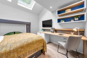a bedroom with a bed and a desk with a computer at Practical Studios In Lincoln with Free Grab&Go Breakfast in Lincoln