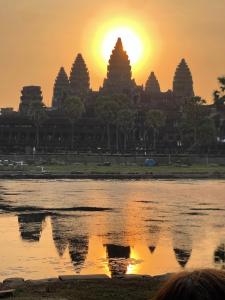 a view of a temple with the sunset in the background at Angkor Nature Voyages in Phumi Ta Phul
