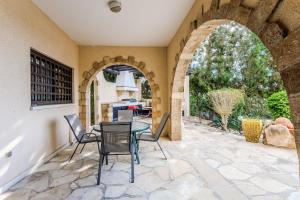 an outdoor patio with a glass table and chairs at Resitour - Kamares Village in Paphos