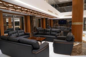 a living room with leather furniture and a table at Coral Hotel Karbala in Karbala