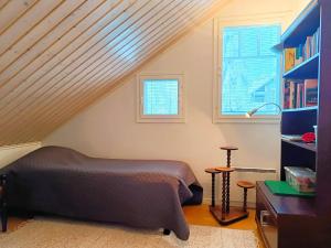 a attic bedroom with a bed and a window at Villa Ilves A in Syöte