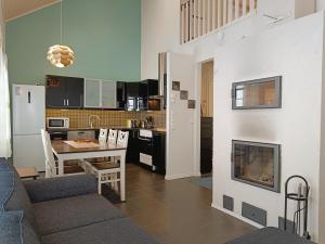 a kitchen and living room with a table and a fireplace at Villa Ilves A in Syöte