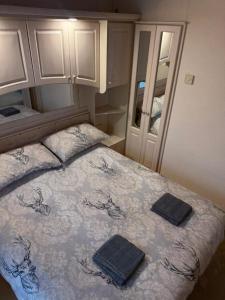 a bedroom with a bed with two towels on it at The West Lakes Caravan in Lamplugh