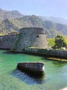 a boat sitting in the water next to a wall at The quiet house in Durrës
