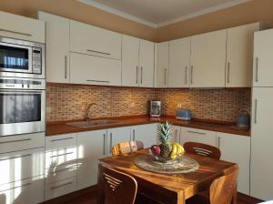 a kitchen with a wooden table with a bowl of fruit on it at Rhodes Soul Luxury Home in Asgourou