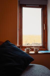 a bedroom with a window with two cups on a table at The Royal Oak in Buxton +19 photos