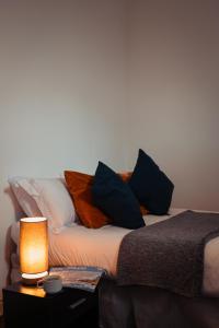 a bed with pillows and a lamp on a table at The Royal Oak in Buxton