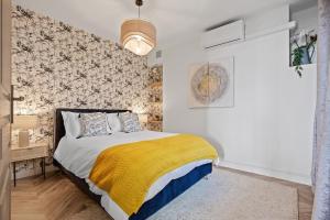 a bedroom with a bed with a yellow blanket at Baie des Anges in Nice