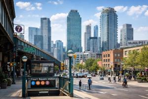 a city street with people walking on the sidewalk and buildings at Court Square Hotel Long Island City New York , Belvilla District 6 Formerly Sonder in Long Island City