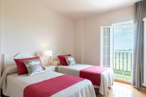 two beds in a room with a large window at Leo San Bruno in Isla Canela +87 photos