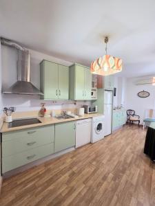 a kitchen with green cabinets and white appliances at The Llanete Collection 01 in Martos +8 photos