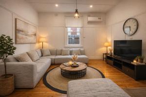 a living room with a couch and a tv at D114 Victorian Central Stay in Melbourne