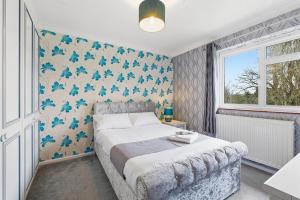 a bedroom with a bed with blue butterflies on the wall at Luxury 5 Bedroom with Pool & Games Room in Potter Street