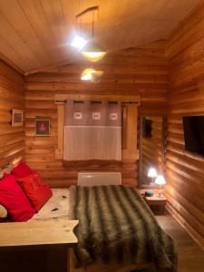 a bedroom with a bed in a log cabin at Chalet Cervus in Font-Romeu-Odeillo-Via