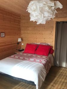 a bedroom with a bed with red pillows and a chandelier at Chalet Cervus in Font-Romeu-Odeillo-Via