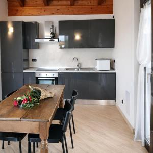 a kitchen with a wooden table with flowers on it at Il Gerlo in Lezzeno