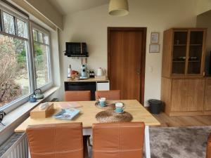 a kitchen with a wooden table with chairs and a table and a table at B&B 't Greefsch Geluck in Kalmthout