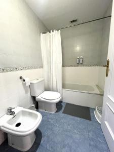 a bathroom with a white toilet and a sink at The Llanete Collection 02 in Martos