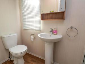 a bathroom with a white toilet and a sink at Caravan B14 Beechrise in Filey +7 photos
